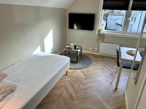 a bedroom with a bed and a desk and a tv at Modern Central Apartment Apt 203 Studio in Stavanger