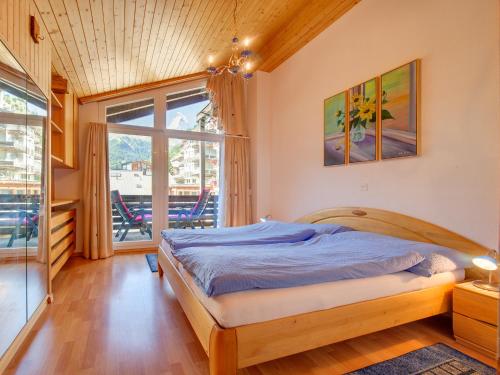 ein Schlafzimmer mit einem Bett und einem großen Fenster in der Unterkunft Haus Armina in Zermatt