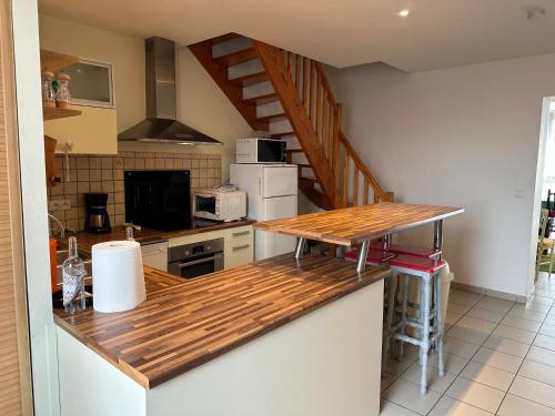 une cuisine avec un comptoir en bois dans une pièce dans l'établissement Appartement 3 Chambres Centre ville, à Lacanau