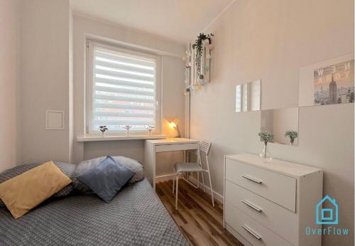 a bedroom with a bed and a desk and a window at Sensational room in Gdańsk