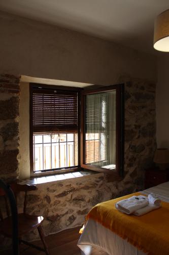 a bedroom with a bed and a window with towels at Casa Paula in Segurilla