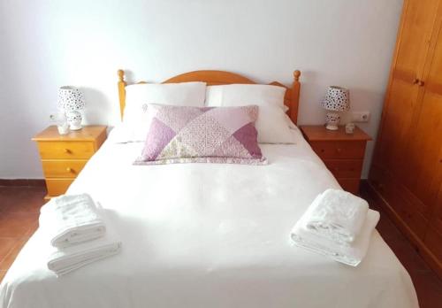 a bedroom with a white bed with towels on it at El Cano Playa Victoria Grupo AC Gestion in Cádiz