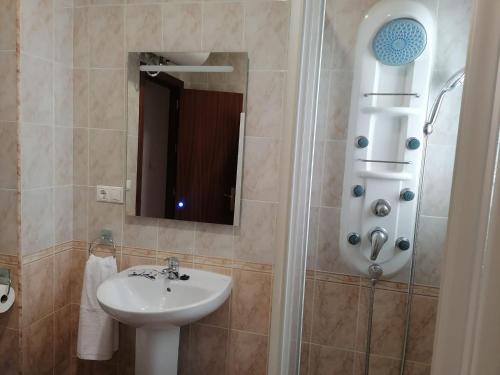 y baño con lavabo y ducha con espejo. en El Cano Playa Victoria Grupo AC Gestion en Cádiz