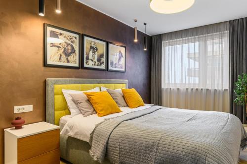 a bedroom with a large bed with yellow pillows at ARA Apart Hotel #4 in Braşov