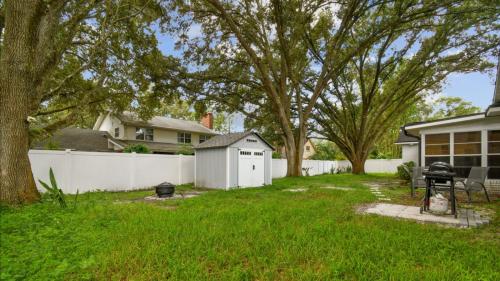 a backyard with a white fence and a grill at Large Guest Rooms in Tampa in Tampa