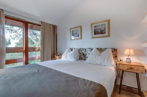 um quarto com uma grande cama branca e uma janela em Villa Lavanda - Kandija em Čunski