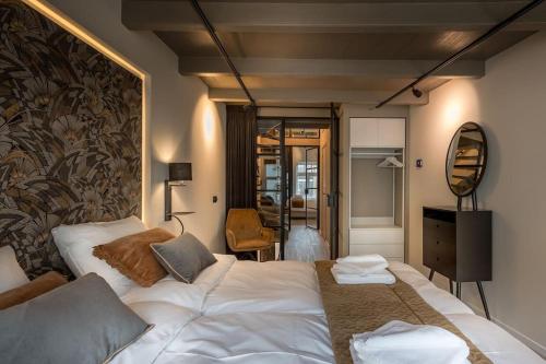 ein Hotelzimmer mit einem Bett und einem Spiegel in der Unterkunft Luxe Herenhuis Huis68 in de binnenstad van Zwolle in Zwolle