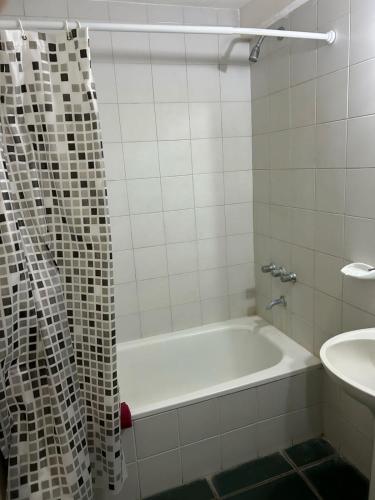 biała łazienka z wanną i umywalką w obiekcie Marítima mono ambiente w mieście Necochea