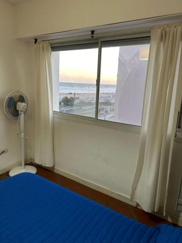 a bedroom with a window with a blue bed and a blue at Marítima mono ambiente in Necochea