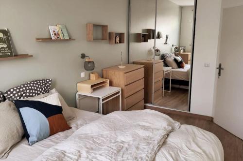 a bedroom with a bed and a mirror at Appartement T3 calme avec jardin privatif in Pontoise