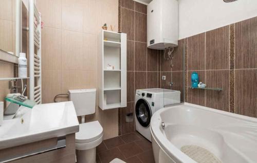 a bathroom with a toilet and a sink and a washing machine at Holiday home in Poljane 47618 in Poljane