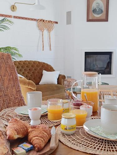 a table with a breakfast of orange juice and croissants at Maison Charmeilles - Gîte touristique - Coliving in Fronsac