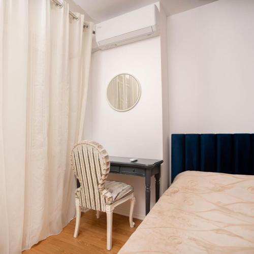 een slaapkamer met een bureau en een stoel naast een bed bij Suprem Apartment Modern Studio Near City Center, Self Check-in & Fast Wi-Fi in Tirana