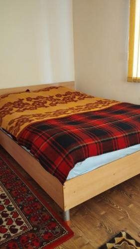 een bed in een kamer met een deken erop bij Дом in Prigorodnoye