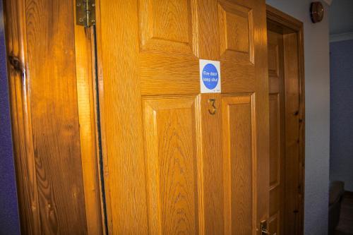 a wooden door with a sign on it at The Coach Inn in Strabane