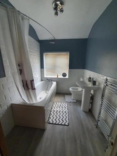a bathroom with a tub and a toilet and a sink at Double Bedroom 96GLC Greater Manchester in Middleton