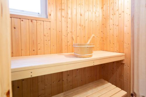 uma sauna de madeira com um balde numa prateleira de madeira em Strandpark Sierksdorf H026 em Sierksdorf