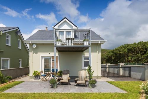 a house with a balcony and two chairs at The Burrow in Dingle