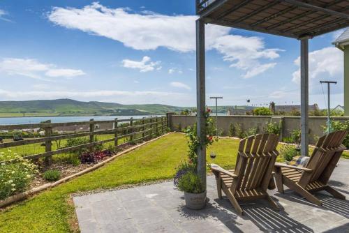 two chairs on a patio with a view of the water at The Burrow in Dingle
