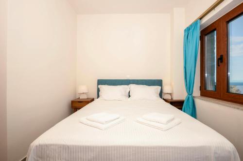 a bedroom with a bed with two towels on it at Maroulas Natura Palace in Giannoudi