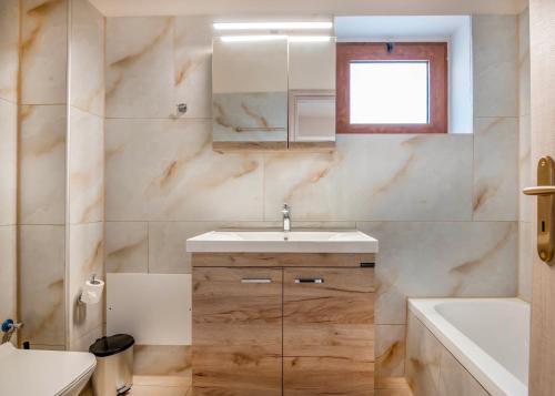a bathroom with a sink and a toilet and a tub at Maroulas Natura Palace in Giannoudi