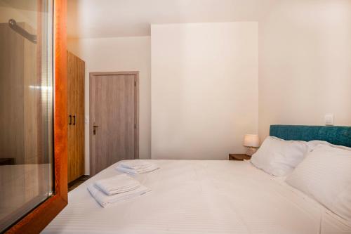 a bedroom with a white bed with two towels on it at Maroulas Natura Palace in Giannoudi