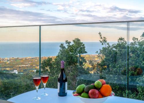 a table with two glasses of wine and a bowl of fruit at Maroulas Natura Palace in Giannoudi