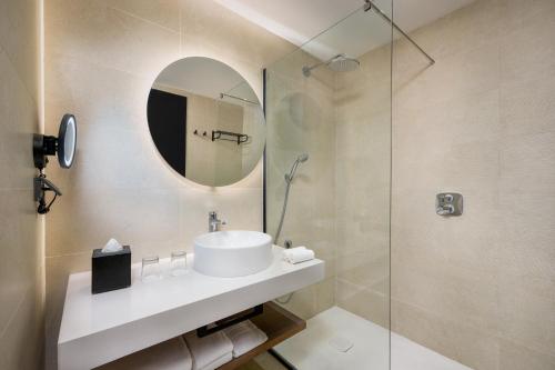 a bathroom with a sink and a glass shower at Radisson Hotel Casablanca Gauthier La Citadelle in Casablanca