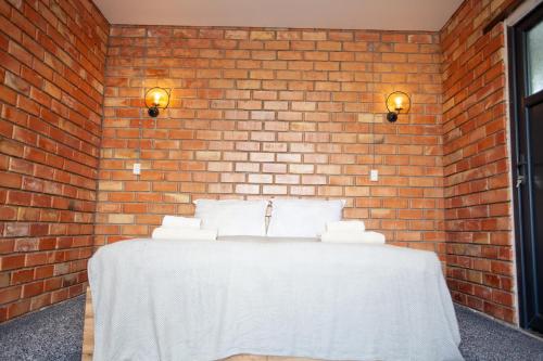 una parete di mattoni con un tavolo bianco con cuscini di Golden street a Cholpon-Ata