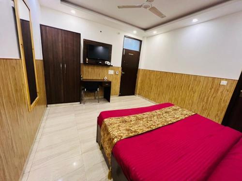 a bedroom with a bed and a desk and a television at Comfortable stay in New Delhi