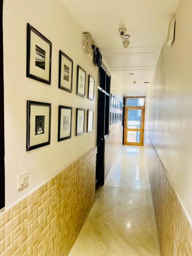 a hallway with framed pictures on a wall with a door at Comfortable stay in New Delhi