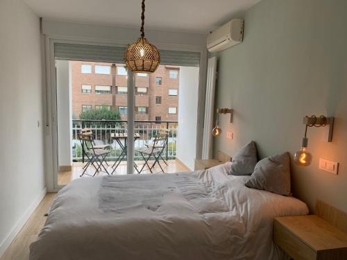 a bedroom with a large bed and a balcony at Piso en Arturo Soria para 5 personas cerca del Aeropuerto y de IFEMA in Madrid