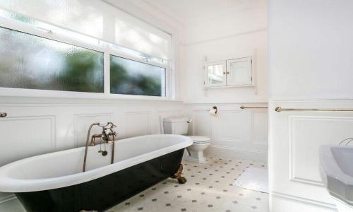 een badkamer met een zwart-wit bad en een toilet bij York Lodge West in Brixham