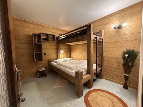 - une chambre avec des lits superposés dans un mur en bois dans l'établissement Appt pied des pistes 53m2 -5pers, à La Bresse