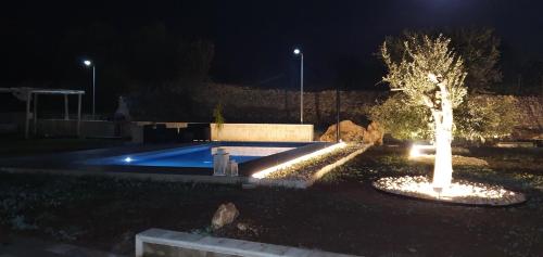 a swimming pool at night with a tree and lights at La Villetta Relais Luxury in Marina dʼAvola