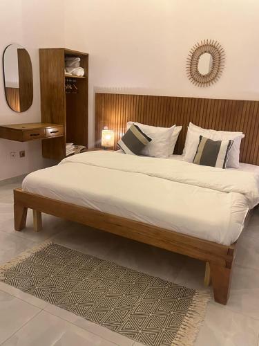 a large bed with white sheets and pillows in a bedroom at River view Kanazi in Niamey