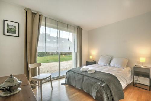 a bedroom with a bed and a large window at Large contemporary pavilion on a hill overlooking Amboise and its château in Amboise