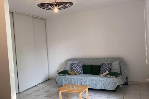 ein Wohnzimmer mit einem Sofa und einem Tisch in der Unterkunft Studio avec terrasse in Montpellier