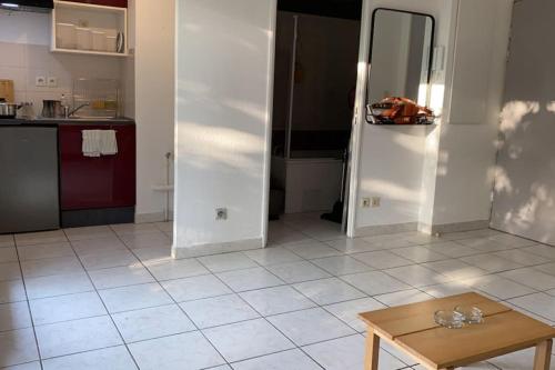 eine Küche mit einem Tisch und einem Kühlschrank in der Unterkunft Studio avec terrasse in Montpellier