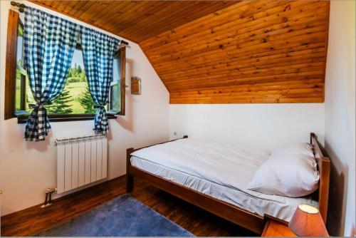 Pine Peaks Palace في زبلجك: غرفة نوم بسرير وسقف خشبي