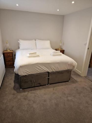 een slaapkamer met een bed met witte lakens en kussens bij Town Center Duplex 6 in Harrogate