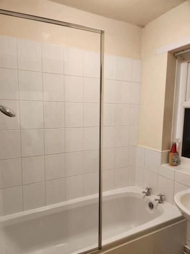 La salle de bains blanche est pourvue d'une baignoire et d'un lavabo. dans l'établissement Double Bedroom TDB Greater Manchester, à Middleton
