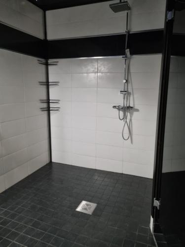 Zimmer mit einer Dusche mit weißen Wänden und Fliesenboden in der Unterkunft Villa Sara in Kalajoki