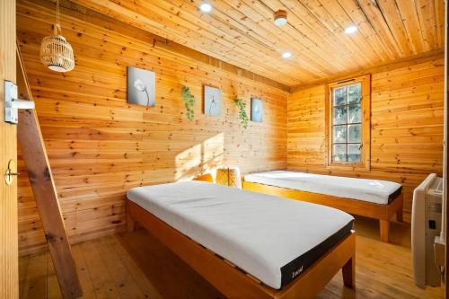 Luxury,cosy Cottage with Hot Tub&Massage beds في كيدرمينستر: غرفة نوم بسريرين في كابينة خشبية