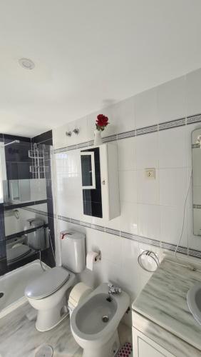 een witte badkamer met een toilet en een wastafel bij Lunamar El mejor Resort en la mejor Playa in Marbella
