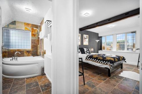 La salle de bains est pourvue d'une baignoire, d'un lit et d'une baignoire. dans l'établissement Luxury,cosy Cottage with Hot Tub&Massage beds, à Kidderminster