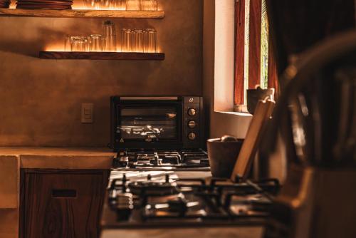 a kitchen with a stove and a toaster oven at Casa Chula Hotel Boutique Frente al Mar in Tierra Blanca