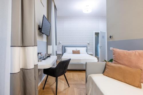 Schlafzimmer mit einem Bett, einem Schreibtisch und einem Stuhl in der Unterkunft Suites Romae Rex in Rom