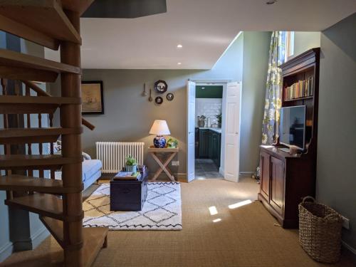 a living room with a staircase and a living room at Luxury Cottage with Swimming Pool in Bredon