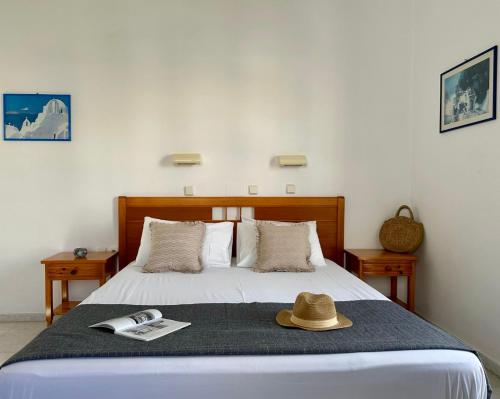 a bedroom with a bed with a hat on it at Ammosis Inn in Naxos Chora